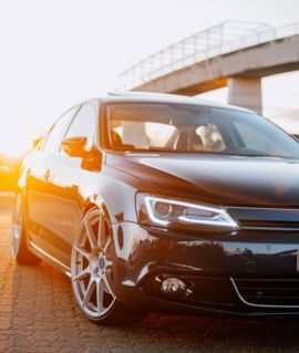 a-black-car-parked-in-front-of-a-bridge.jpg a black car parked in front of a bridge